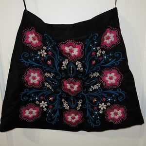 Black velour skirt with embroidered pattern.